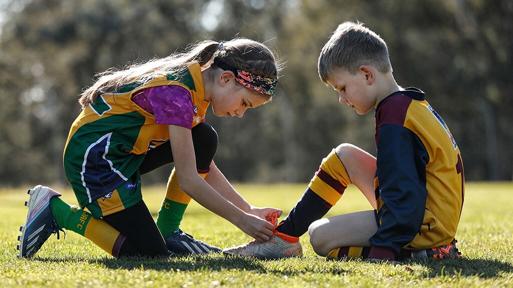 Goodfortfootyjuly25.jpg Young Wildcat Gemma Klose is always happy to help tie shoelaces - AFL
